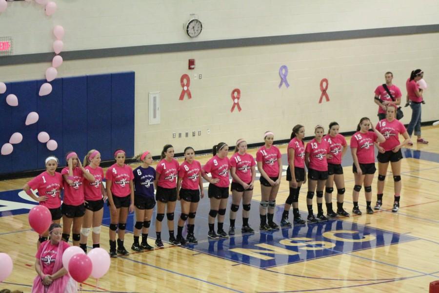 Photo by Andrea Sodt
Coach Atkinson stands with her girls during the national anthem at their volley for the cure game.