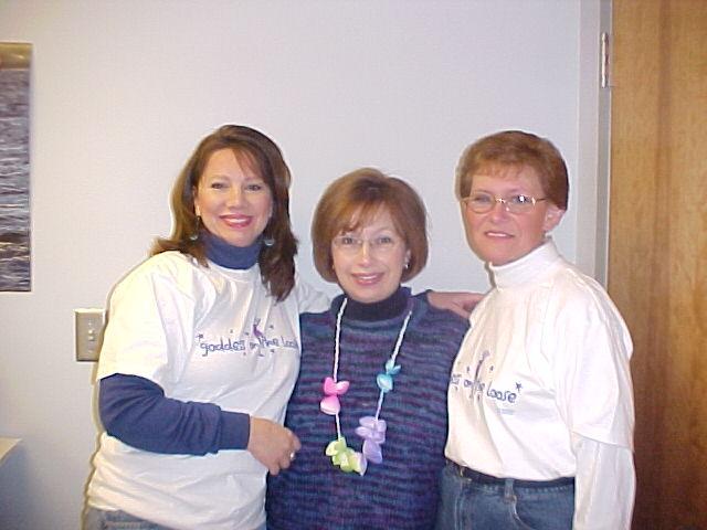 Kathleen Stewart smiling for the camera with Pam Pleviak and Linda Blasko. Pleviak was Stewarts first boss, who also graduated from ACHS in 1976. Stewart read to Blaskos children in storyhour at the Lake Villa Library when she worked as the Childrens Librarian. 