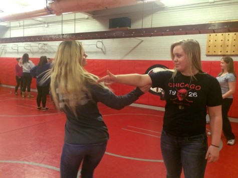 Junior Natalie Nielsen and senior Natalie Ivins practicing how to disarm an attacker.