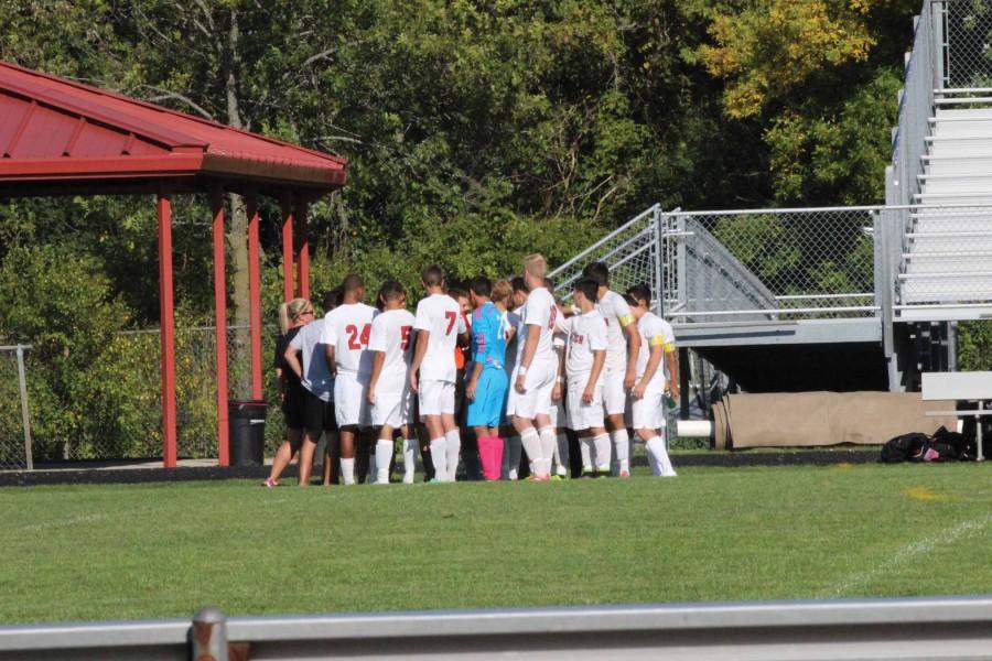 The ACHS boys varsity soccer team huddles up before a game.