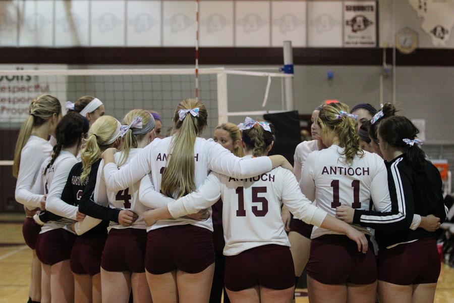 The girls varsity volleyball team form a huddle before a game against Wauconda on Oct. 5, 2014.
