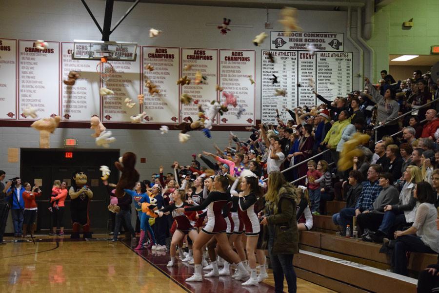 Students toss stuffed animals onto the court to donate for the special olympics.