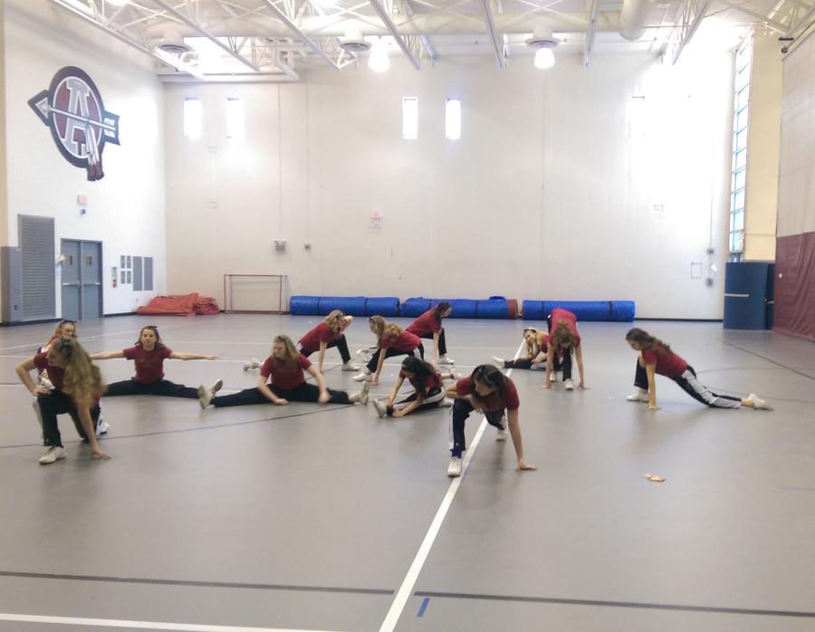 The Antioch varsity dance team stretches before their performance before the boys basketball game.