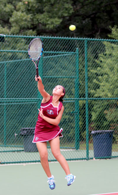 Returning state qualifier, Sjana Henderson (12), rallies the ball back to her opponent in her match soundly Thursday night. The Sequoits beat Lakes 6-1. Caption by Jill Foote