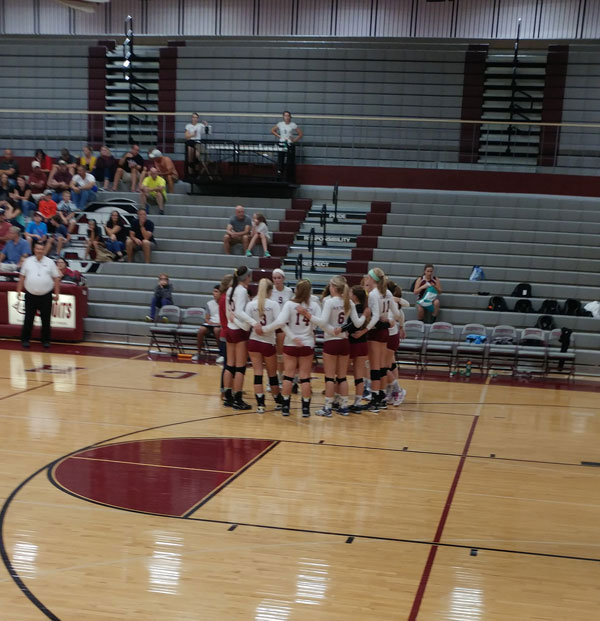 The+volleyball+girls+gather+for+a+timeout+during+the+intense+game.