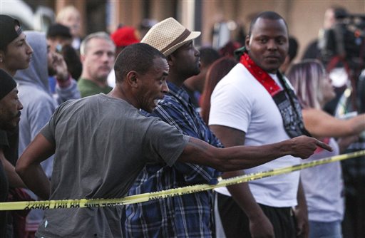 A man points at police as he and others yell at police while at the scene where a black man was shot by police in El Cajon, east of San Diego, California on Tuesday, Sept. 27, 2016. 