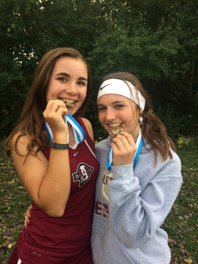 Sophomores Piper Foote and Megan Lawrence show off their medals after placing 2nd in their meet.