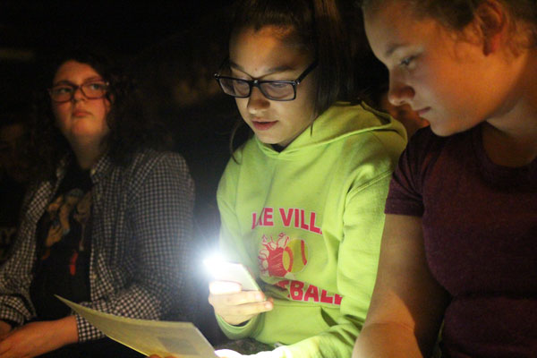 With Halloween approaching, freshman Olivia Collins takes part in a Scary Book-talk in the bomb shelter. Illuminated by the glow of her phone, Olivia reads from a list of Illinois Top Ten Haunted Schools. ACHS ranks fourth. Caption by Caleigh Nixon