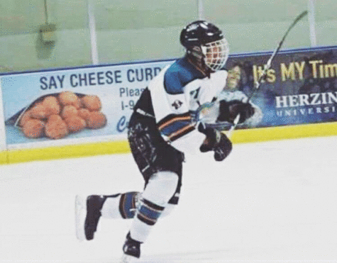 Senior Warren Sundt skates towards the puck during a hockey game.