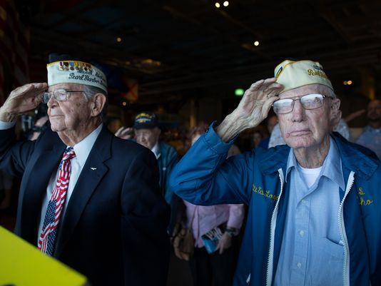 Two Pearl Harbor veterans stand and salute the flag during the moment of silence in remembrance of those who lost their lives in the 1941 attacks, which saw its 75th anniversary on Wednesday, December 7th.