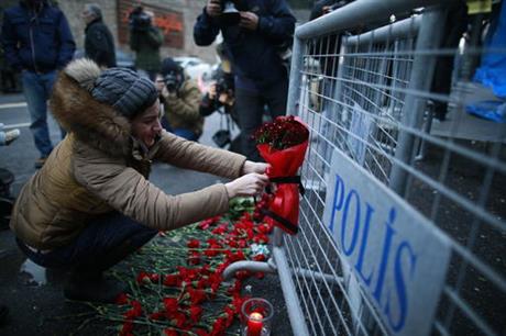A young woman cries as she leaves flowers for the victims outside a nightclub which was attacked by a gunman overnight in Istanbul, Turkey on New Years Day.