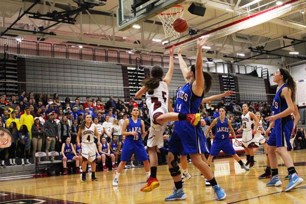 Shooting a layup, senior Amy Reiser fights off a Lakes defender. The lady Sequoits defeated rival Lakes Community High School, Thursday, January 6, 50-40. Before the game, Coach Borries told us Lakes was going to be aggressive. He wanted us to go hard at the basket, while protecting the ball, sophmore Piper Foote said.  Caption by Noor Abdellatif