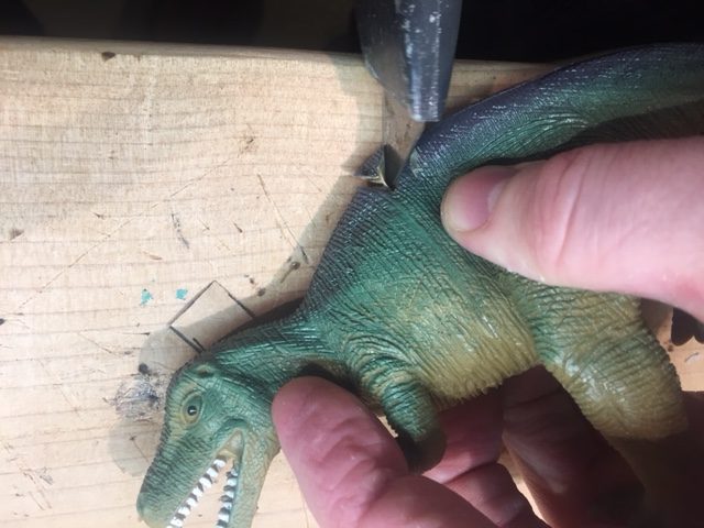 Cut a groove into the back of the dinosaur, where you want the heel to stick through.