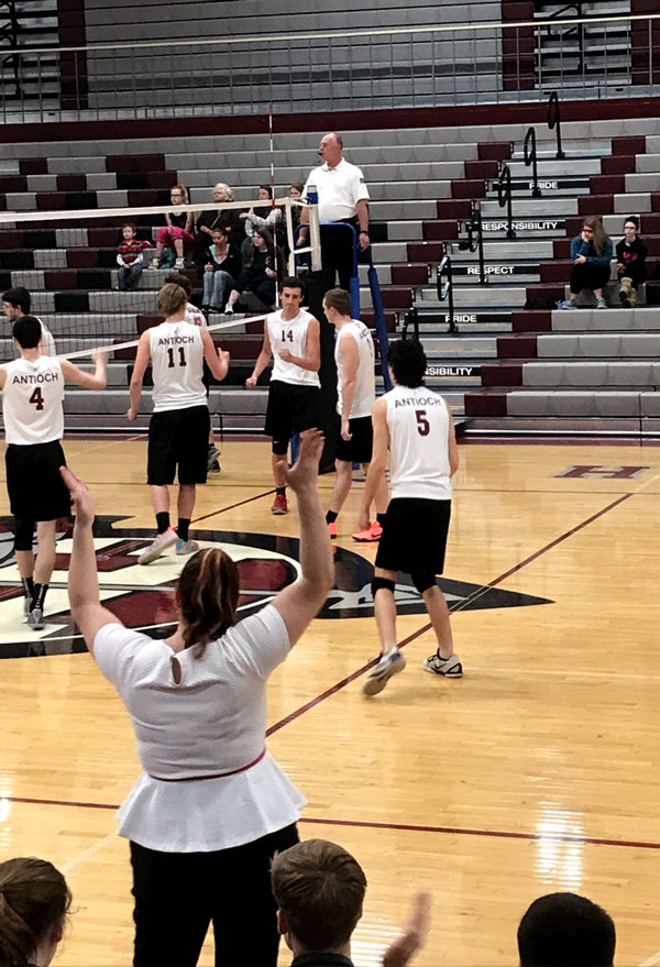 Joseph Whittall high fives team members during the rough game against Grant.