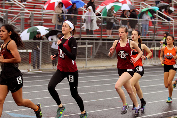Senior Rylie Mercer and junior Allison Morris run the 3200 despite the rain. Mercer ran a personal best for this event in despite the weather.