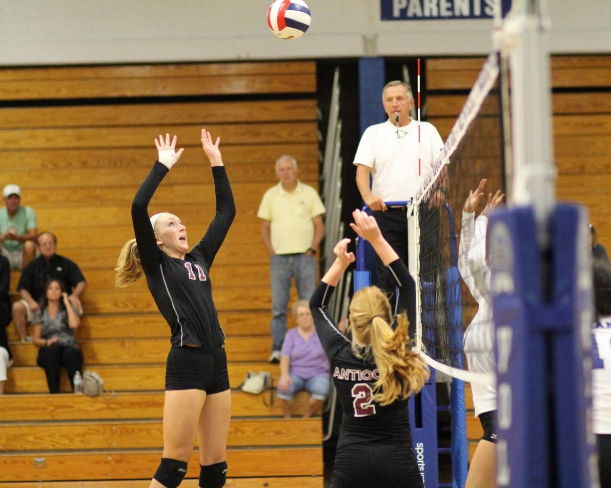 Seniors Katherine Barr and Kennedy Moll move the ball through the front row to get a kill on offense.