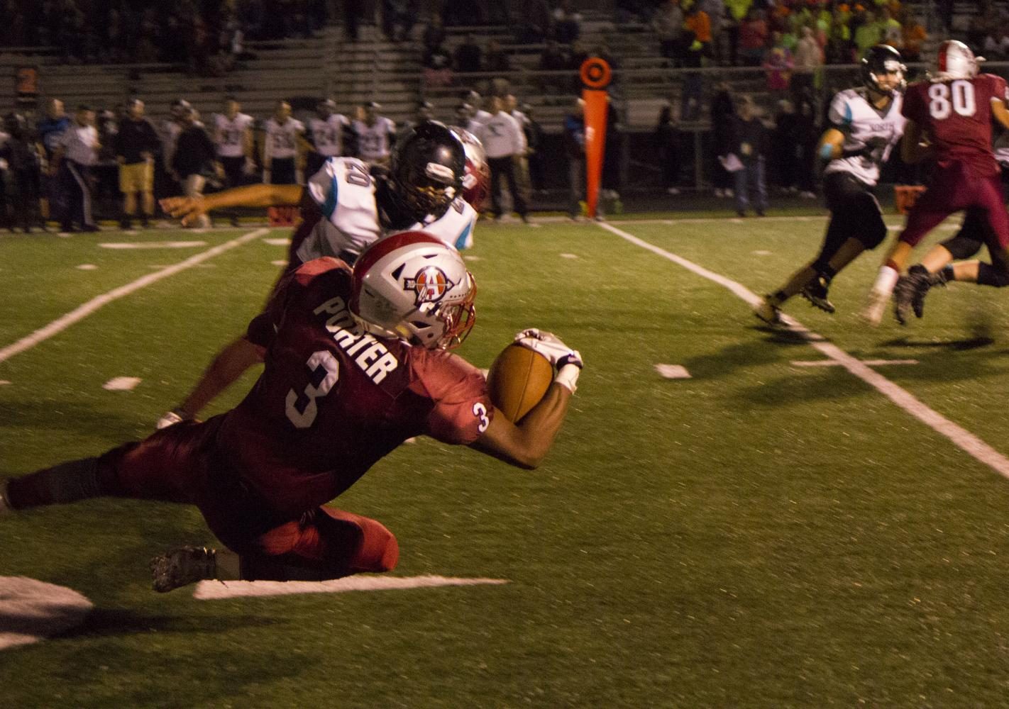 Senior Drew Porter falls to his knees to catch a pass in Friday nights game against Woodstock North.