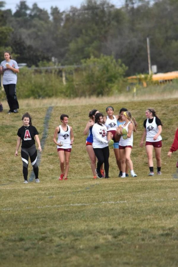 Runners from Antioch and Lakes help carry teammate to the finish line.