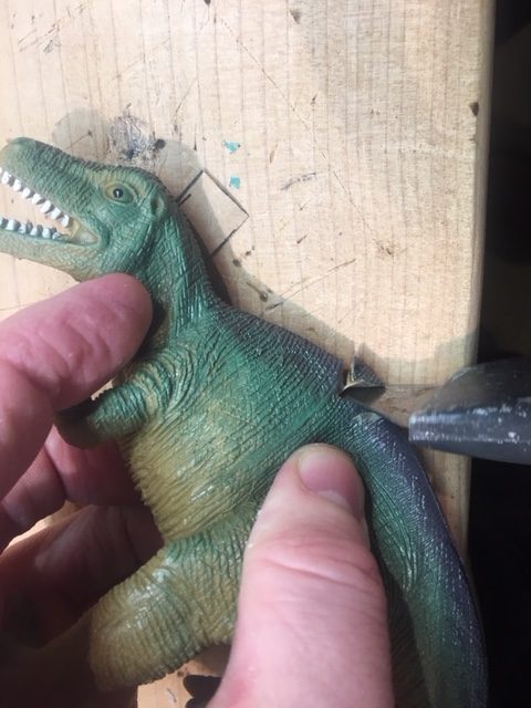 Cut a groove into the back of the dinosaur, where you want the heel to stick through.