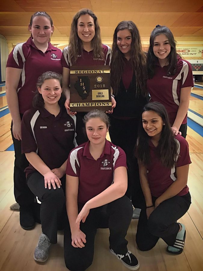 The bowling team shows off their regionals plaque.