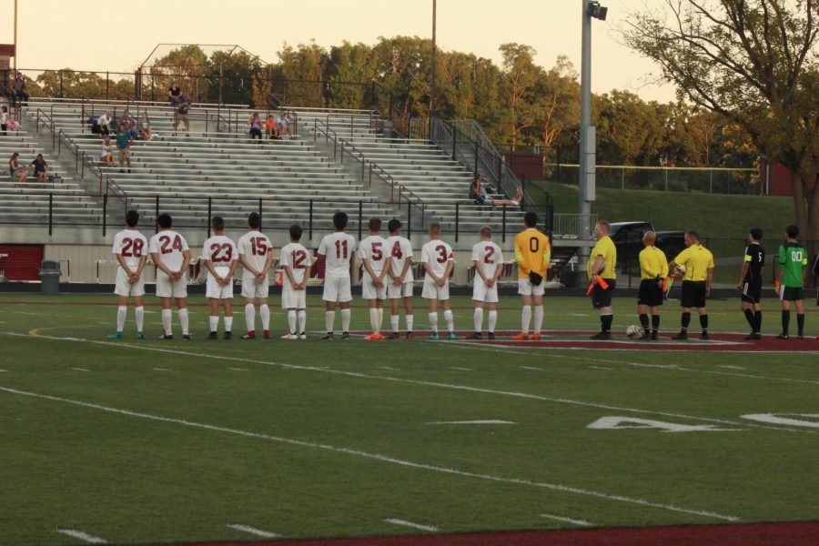 The+boys+varsity+soccer+team+lines+up+to+listen+to+the+national+anthem.
