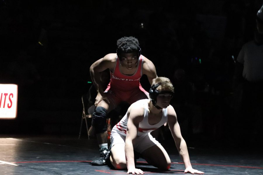 Senior Jackie Sistrunk gets ready to mount his opponent during the second half of his match.