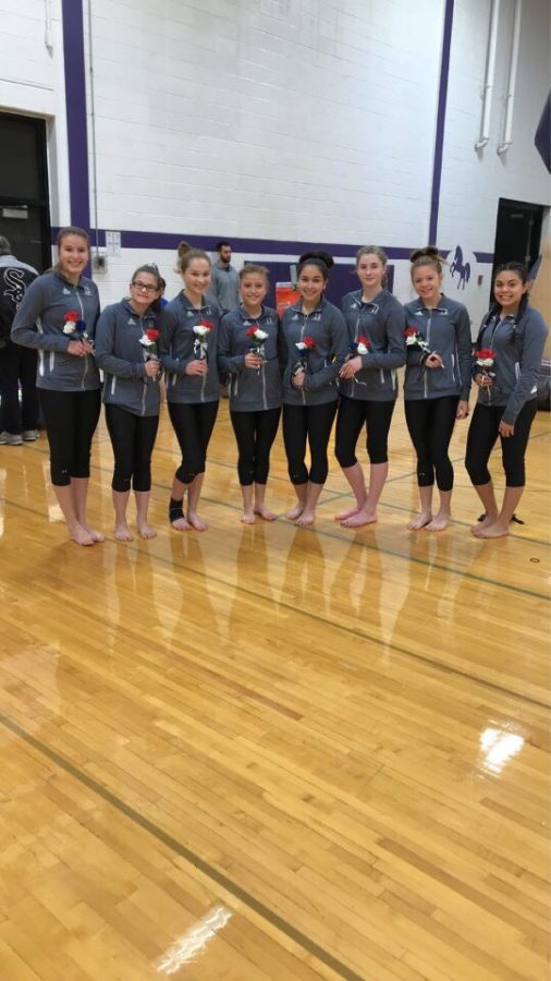 Gymnasts hold flowers after finishing another season.