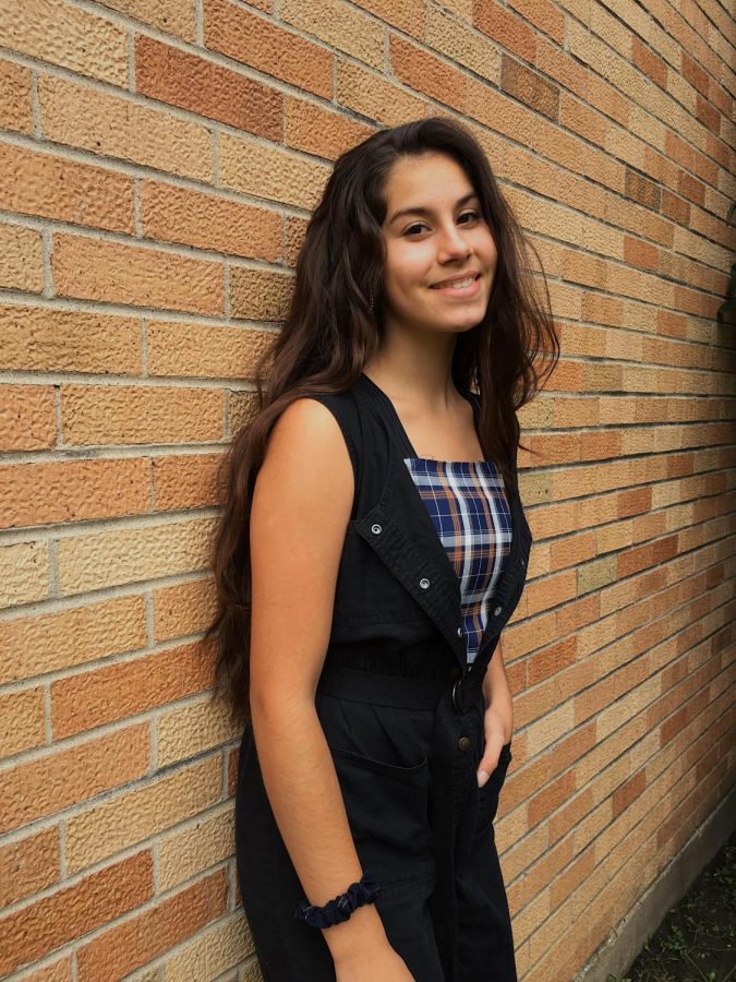 Sophomore Autumn RIzzo is wearing a black jumpsuit with a plaid tank top.