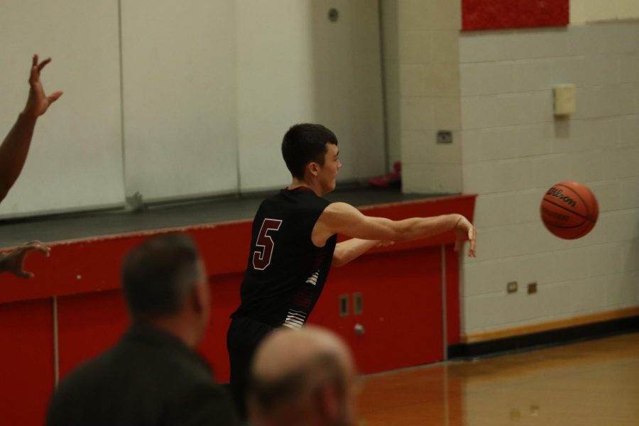 Senior Gavin Eldridge passes the ball inbounds to fellow teammateKobe Kriese under their opponents net.