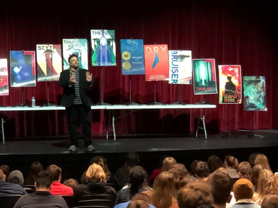 Pictured are Shusterman and his assorted works. From left to right, they are: The Shadow Club, Full Tilt, Unwind, Scythe, Thunder Head, The Tull, Challenger Deep, Dry, Bruiser, Everlost, Scorpion Shards and Teslas Attic.