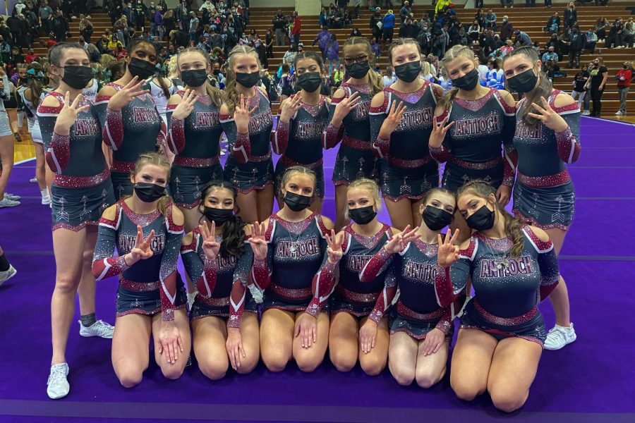 The varsity cheer team poses holding up threes after a third-place finish at the Belvidere sectional.