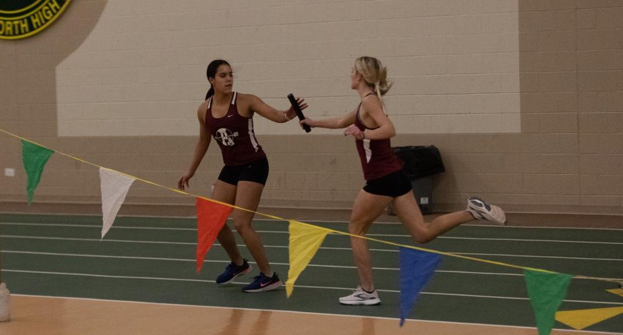 Junior Julia Kraus hands off the baton to sophomore Zamora Rodriguez in the 4x400 meter race.