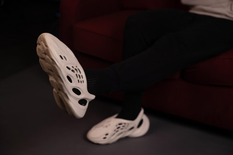 Junior Jake Mallek models his white adidas Yeezy foam RNNR shoes.