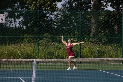 Sophmore Avina Doty serving in her tennis match against Lakes.