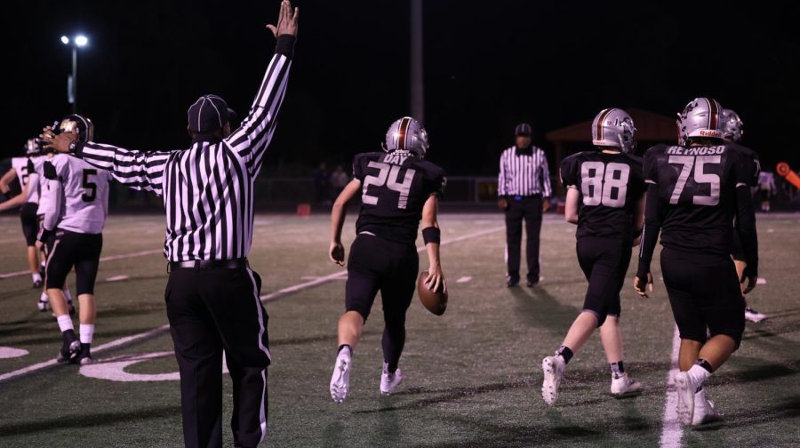 Junior Nick Day giving the ball to a ref after a run.