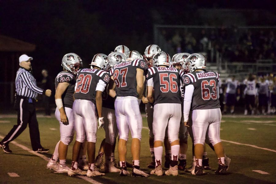 The Sequoits offense in a huddle.