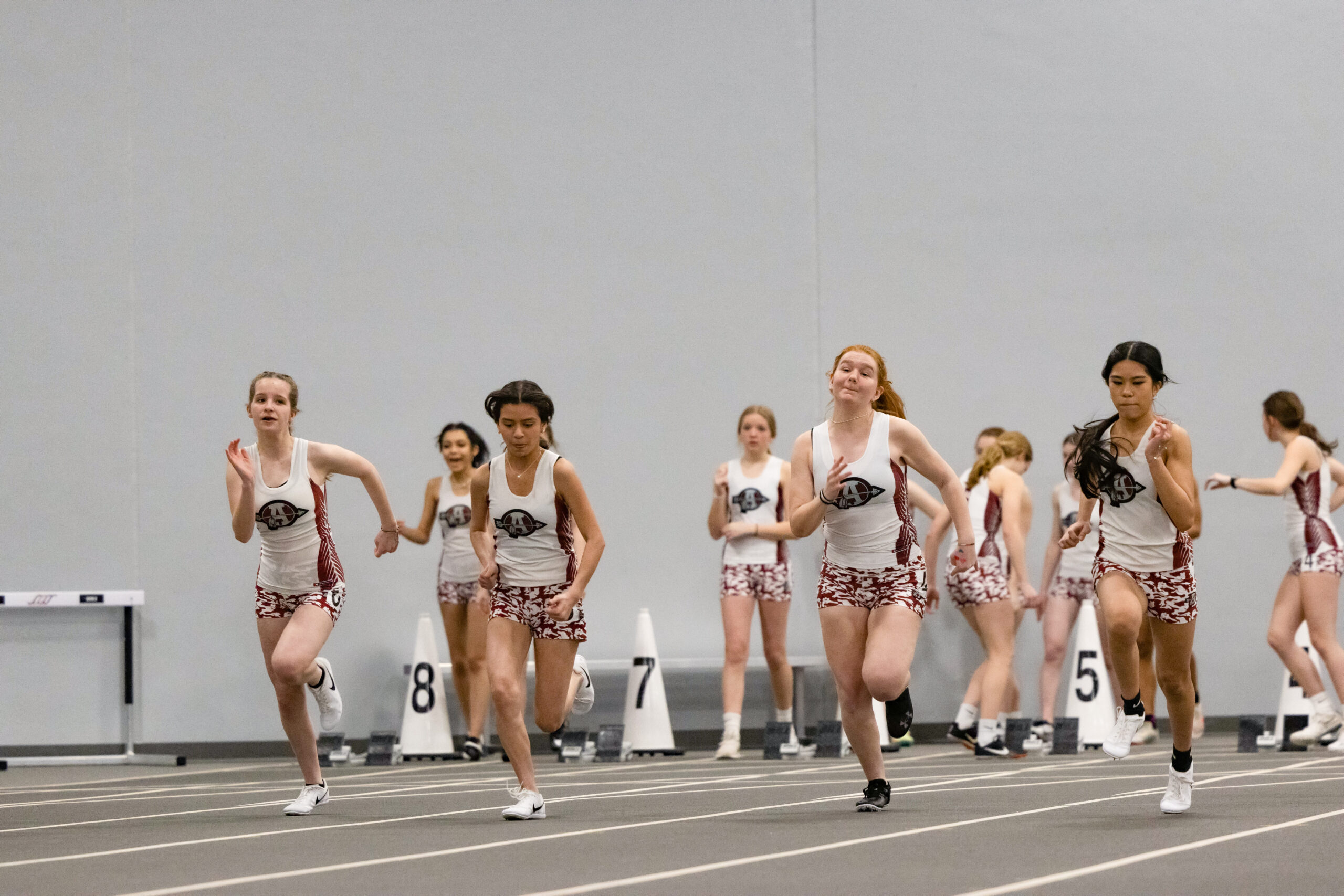 The underclassmen girl track members participate in the 60-meter dash.